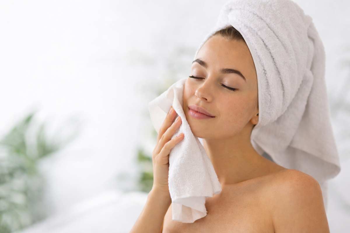 Pelle giovane con il trucco dell'asciugamano